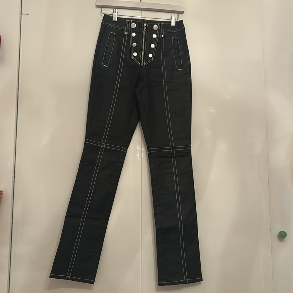 Steele black leather pants with button and zipper detailing in front.